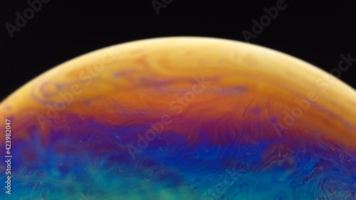 Close up of hidden beautiful and colourful of half soap bubble with abstract pattern on surface isolated with black background.