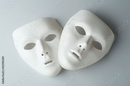 White theatre masks on grey background, flat lay