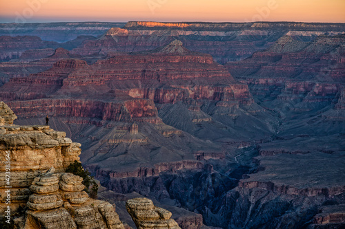 Man stands up waiting for sunrise in Grand Canyon National Park