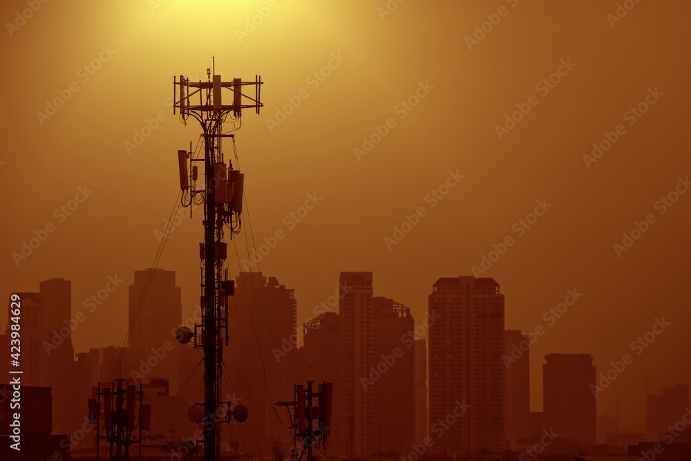 Silhouette of, Telecommunication transmitter tower on backdrop of city view and sunny sky with copy space, Cellular base station network antenna 4G, 5G, Transmission technology and internet signals.