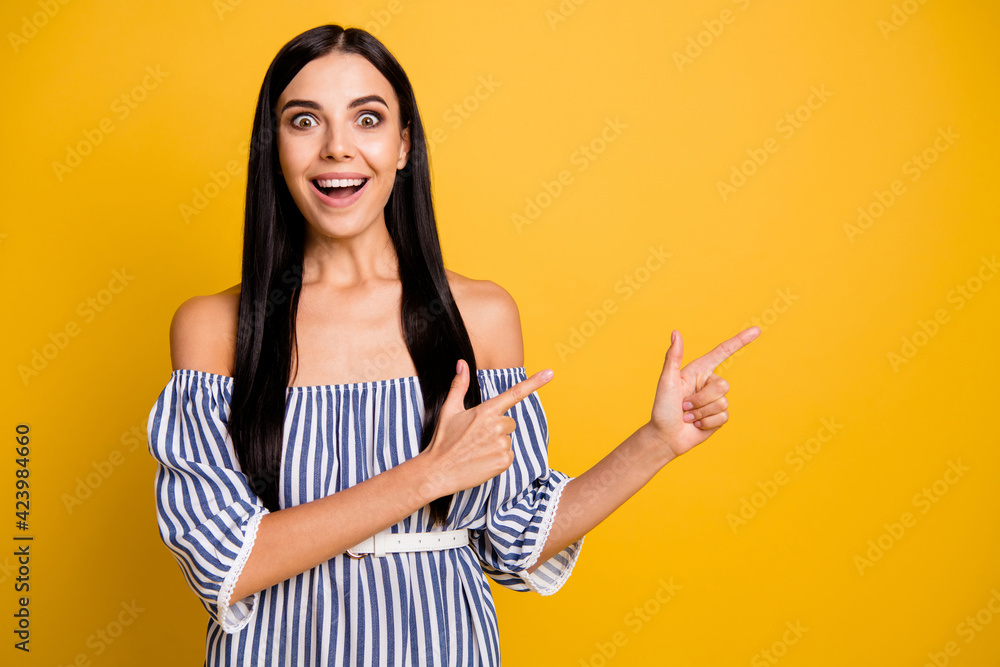 Photo of shocked funny young woman dressed off-shoulders dress pointing empty space two fingers isolated yellow color background Photo of shocked funny young woman dressed off-shoulders dress pointing empty space two fingers isolated yellow color background