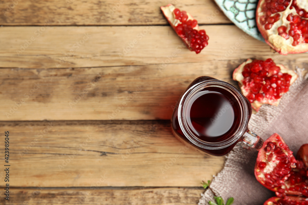 Pomegranate juice in mason jar and fresh fruits on wooden table, flat lay. Space for text Pomegranate juice in mason jar and fresh fruits on wooden table, flat lay. Space for text