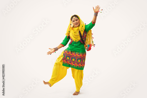A Giddha dancer performing a dance step with hand gestures. 