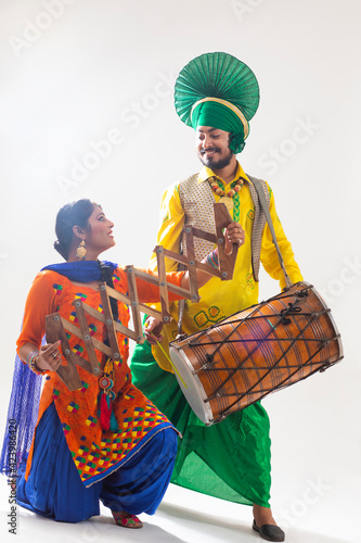 A Bhangra and A Giddha Dancer Performing with a Dhol and Saap.	 photo