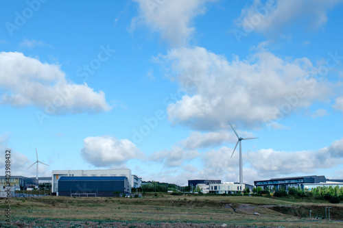 An electricity generating windmills in the countryside against blue cloudy sky 
