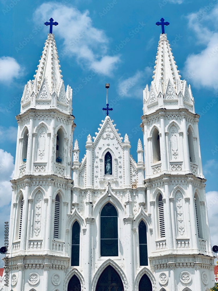 Basilica of Our Lady of Good Health, Sanctuary of St. Mary's shrine, Cathedral of St. Mary, facade of holy trinity. Roman Catholic Latin church tower against blue sky background in Velankanni.