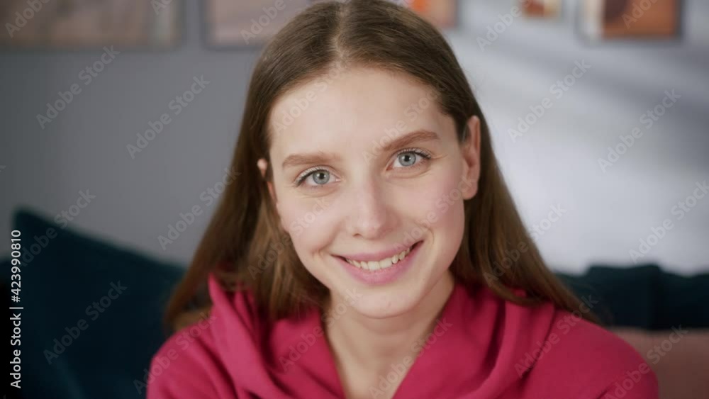 Young woman is looking at camera. Portrait of attractive model sitting on sofa. Beautiful happy smiling mother at home, being lockdown, post covid quarantine. Young woman is looking at camera. Portrait of attractive model sitting on sofa. Beautiful happy smiling mother at home, being lockdown, post covid quarantine.