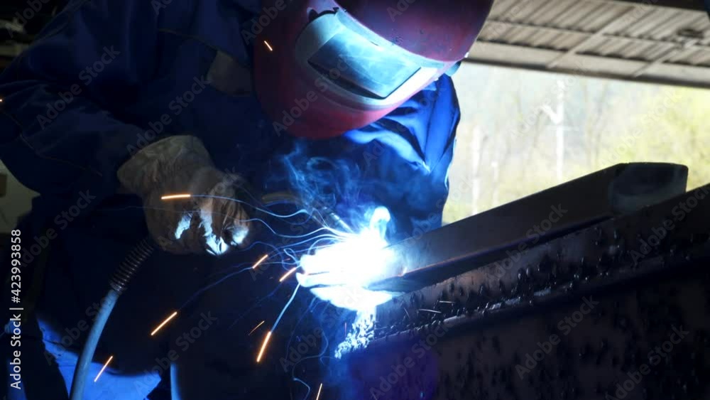 Anonymous workman welding metal construction in workshop Anonymous workman welding metal construction in workshop