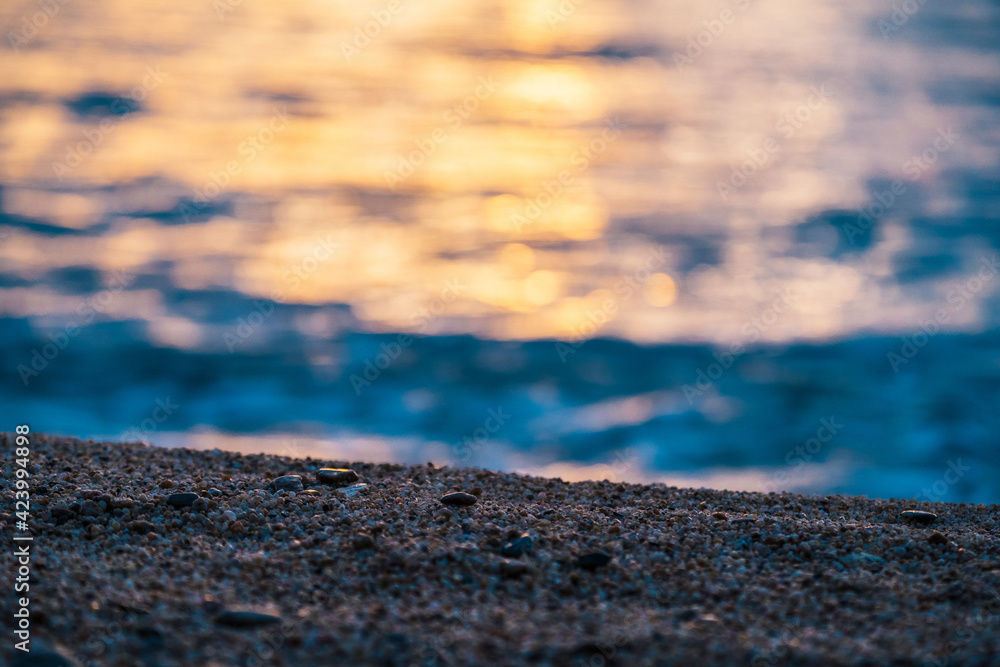 Selective focus on the sand on the beach during sunset at sea. Selective focus on the sand on the beach during sunset at sea.