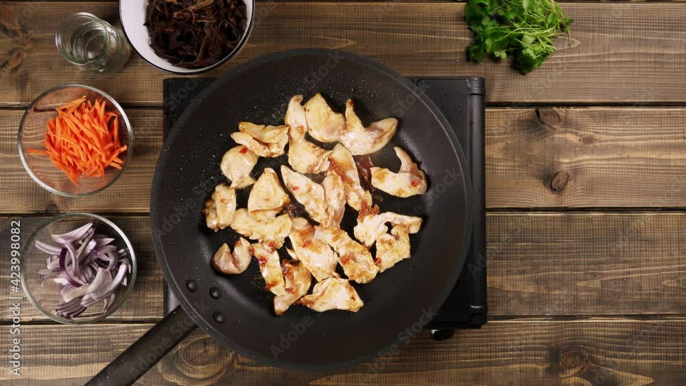 Chicken breast cut into a pieces, fried in a pan. Top view. Chicken breast cut into a pieces, fried in a pan. Top view.
