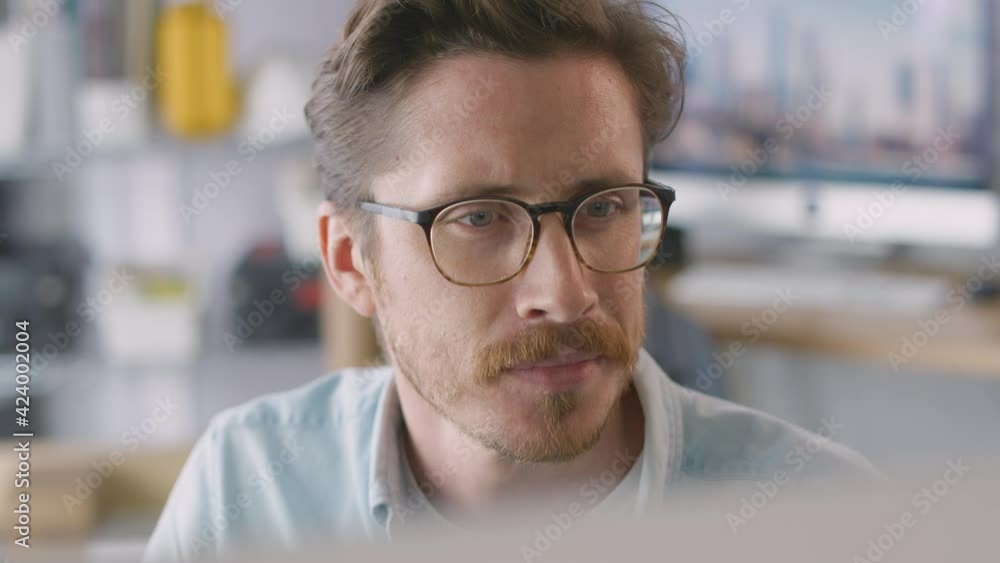 View from behind screen as male architect works on desktop computer in office - shot in slow motion View from behind screen as male architect works on desktop computer in office - shot in slow motion
