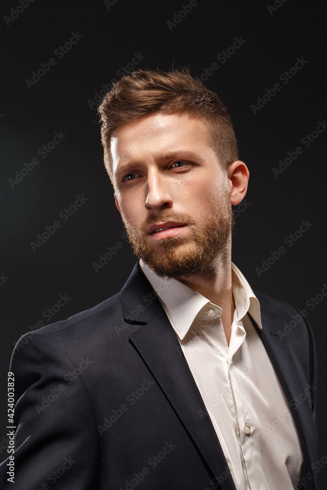 A man wearing a suit and tie on black background A man wearing a suit and tie on black background