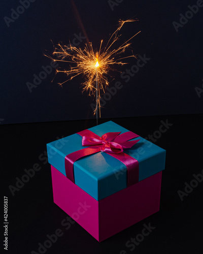 gift box with a sparkler on dark background