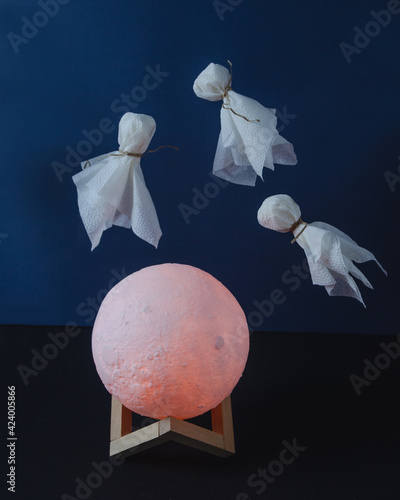 levitating ghosts in over the moon on dark background photo