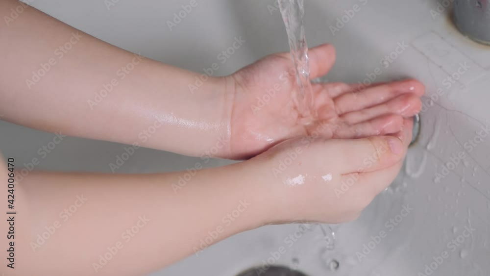Wash hands. Little boy washes her hands in the bathroom. Baby washes her hands in the bathroom with running water. Children hand washing with tap. Wash hands. Little boy washes her hands in the bathroom. Baby washes her hands in the bathroom with running water. Children hand washing with tap.