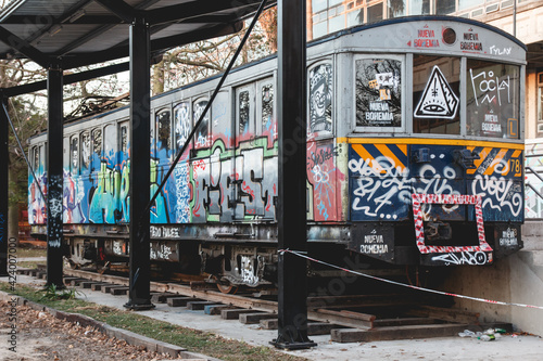 Piece of metro train sitting in the outside of the university with graffiti