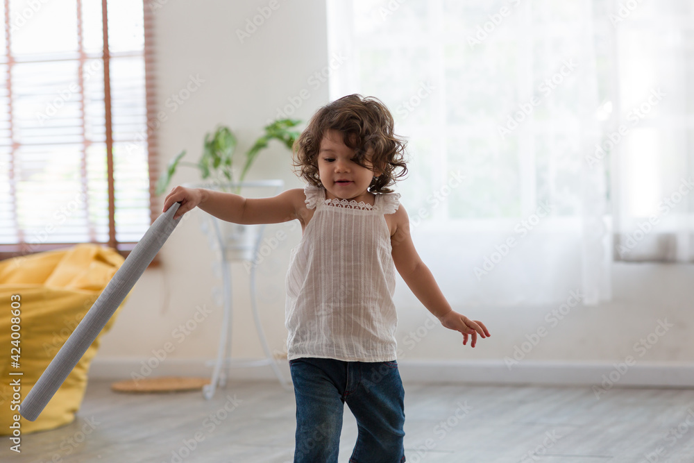 Cute toddler little baby girl with curly hair running and playing on floor at home Cute toddler little baby girl with curly hair running and playing on floor at home