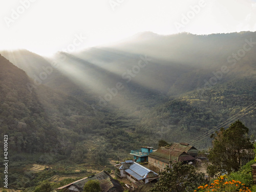 Sun rays streaming through green hills photo