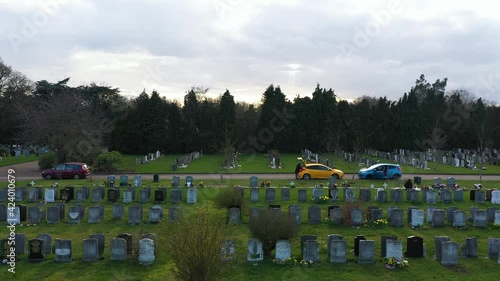  SIDE REVEAL OF A MAN AND A YELLOW CAR AT THE CEMETERY, AERIAL photo