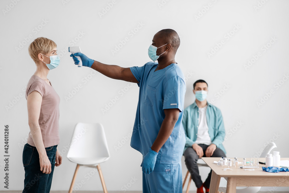 Obraz premium Medical staff caring for patient, check first symptoms of covid-19 virus and preparing for population vaccination