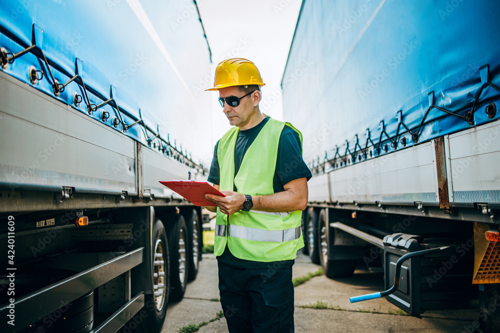 Professional male industrial truck driver with yellow protective helmet