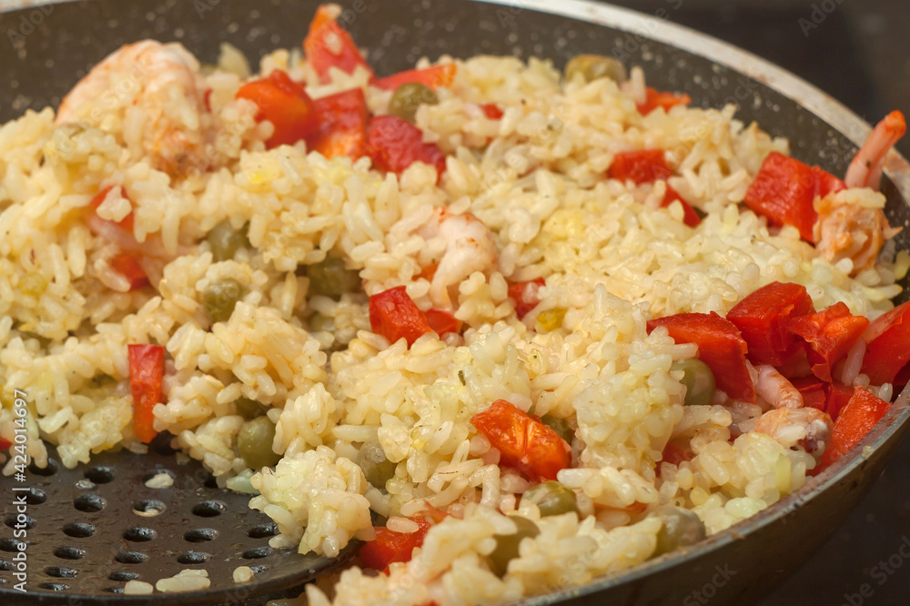 Rice with shrimp and vegetables, risotto, pilaf in a black pan, wooden background. to interfere Rice with shrimp and vegetables, risotto, pilaf in a black pan, wooden background. to interfere