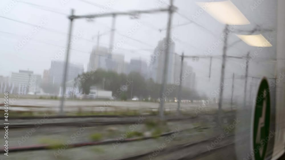 Railroad tracks and street with cars seen from train traveling to Amsterdam Railroad tracks and street with cars seen from train traveling to Amsterdam