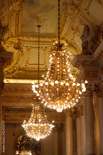Different details of a luxurious theater with gold touches and stained glass