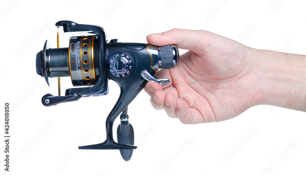 Fishing reel for fishing rod in hand on white background isolation Fishing reel for fishing rod in hand on white background isolation