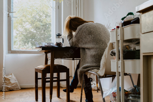 Rear view of woman sitting on chair at home