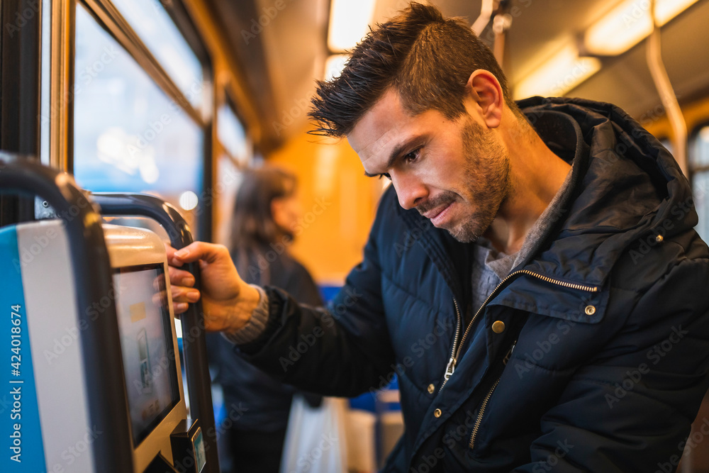 Smiling man buying ticket while commuting through tram Smiling man buying ticket while commuting through tram