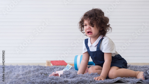 Photos Cute little girl crying on the carpet feeling upset not getting what she wants