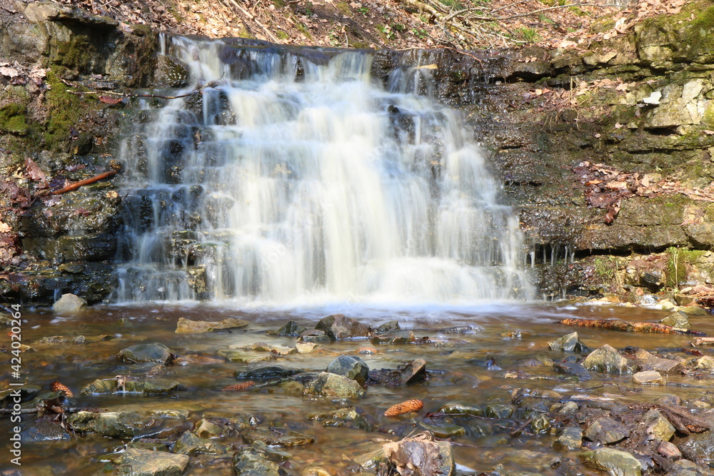 Obraz premium Spring, a waterfall in the forest, stones, moss. Long exposure