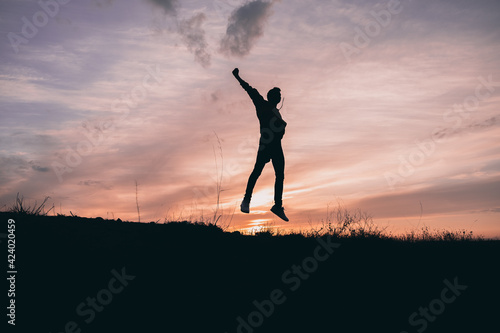 Young boy silhouetted jumping for freedom © Daniel