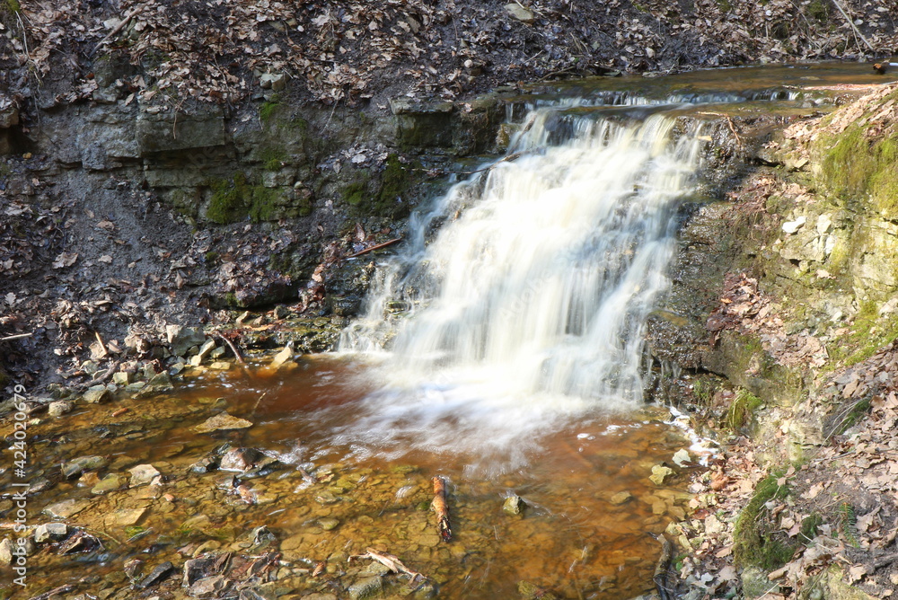 Spring, a waterfall in the forest, stones, moss. Long exposure Spring, a waterfall in the forest, stones, moss. Long exposure