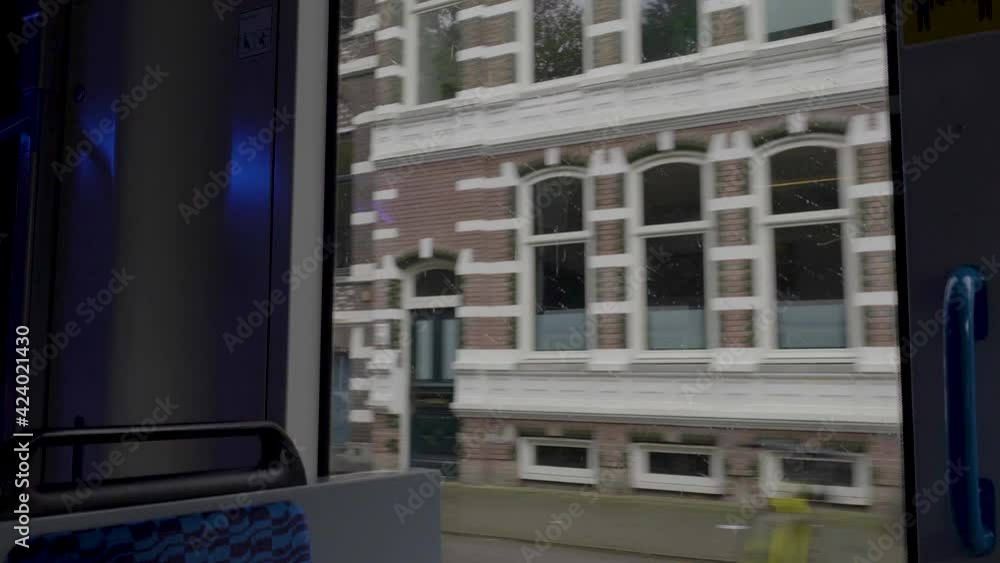 Looking through window of moving tram along street in Amsterdam Looking through window of moving tram along street in Amsterdam