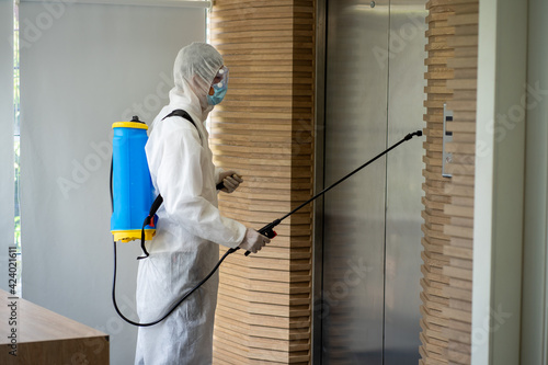 Asian healthcare medical workers wearing PPE protective suit disinfecting to building in new normal 