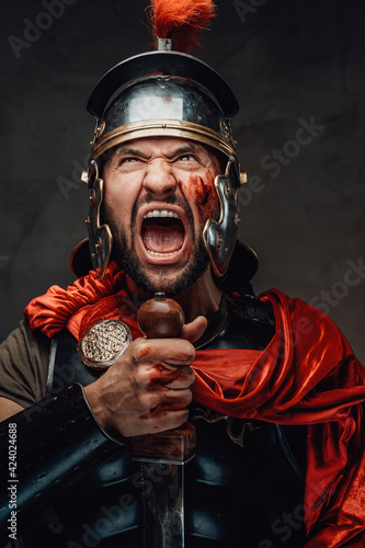 Roman warrior screaming looking up in dark background