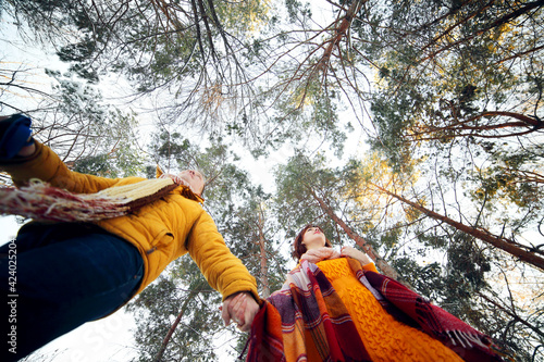 Cheerful young couple walking in the winter forest, low angle
