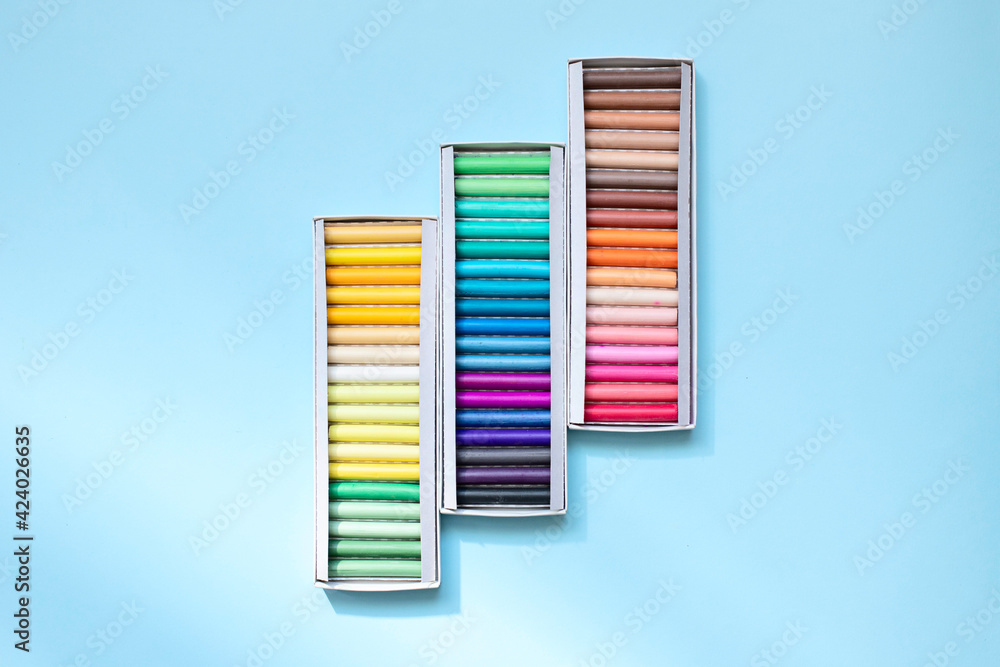 Obraz premium Colorful chalk crayons for drawing on a blackboard and on asphalt.