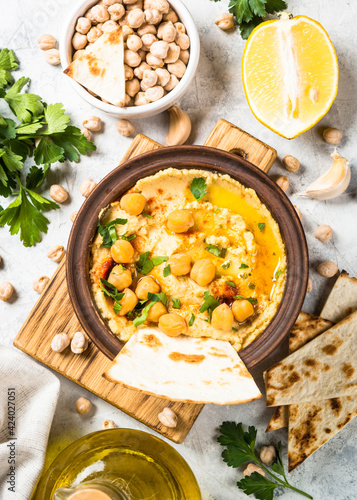 Hummus with olive oil and paprika at light kitchen table.