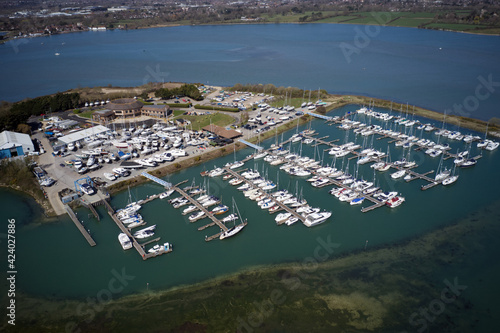 Northney Marina with moored yachts and boats on the pontoons situated on shore of Hayling Island in the beautiful Langstone Harbour., aerial photo. photo