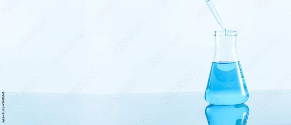 Laboratory glassware with blue liquid on white background Laboratory glassware with blue liquid on white background