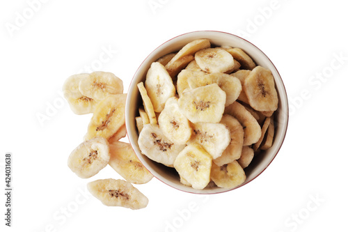 Bowl with sweet banana slices on white background, top view. Dried fruit as healthy snack