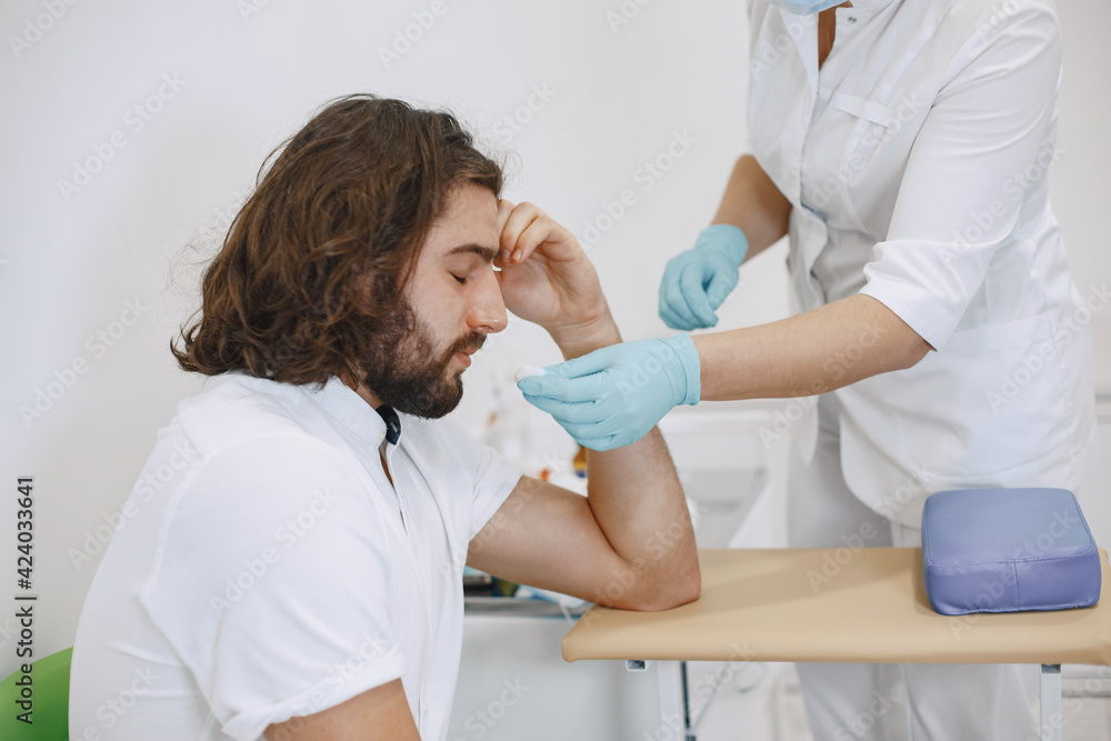 Fototapeta premium Nurse taking blood sample from patient at the doctors office