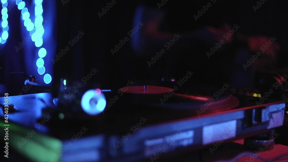 Dj put vinyl record on turntable on concert stage in nightclub.Professional disc jockey playing music on rave party in the club with retro style turn table player, close up video clip Dj put vinyl record on turntable on concert stage in nightclub.Professional disc jockey playing music on rave party in the club with retro style turn table player, close up video clip