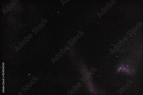 Winter night sky at Orion constellation, Messier 42 nebula in right down corner, bright yellow Betelgeuse star left side and blue Bellatrix above