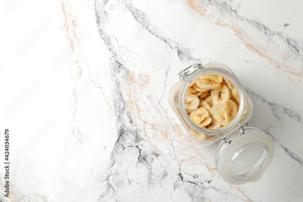 plate with banana slices on marble table, top view. Dried fruit as healthy snack plate with banana slices on marble table, top view. Dried fruit as healthy snack