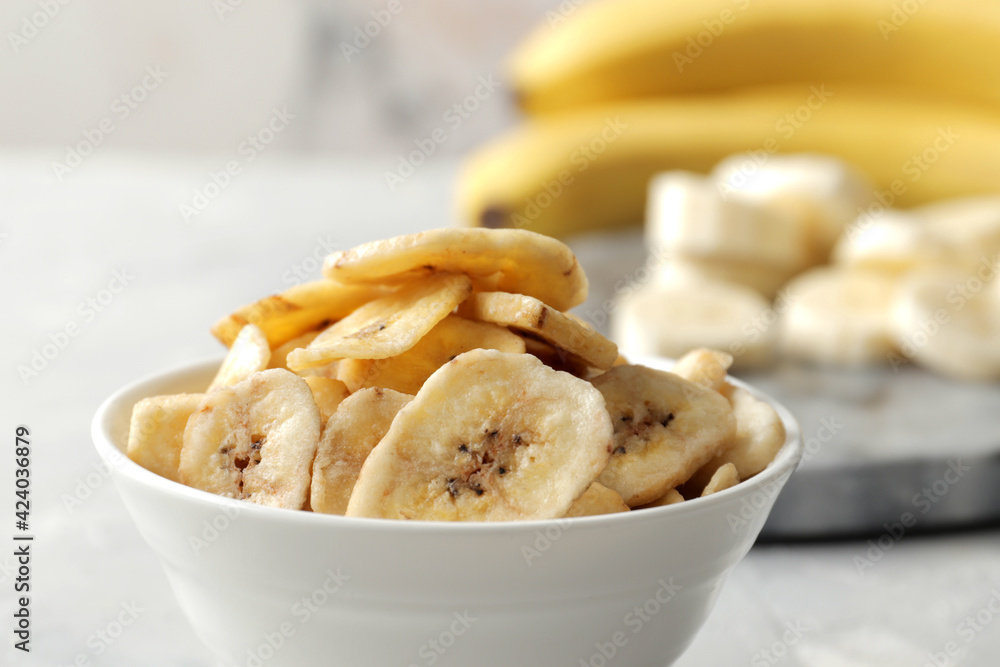 Composition with sweet dried banana slices, fresh bananas on a marble wooden background. Dried fruit as healthy snack Composition with sweet dried banana slices, fresh bananas on a marble wooden background. Dried fruit as healthy snack