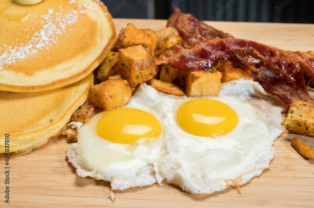 Diner style slam breakfast. Two eggs sunny side up, bacon, hash browns, and two pancakes. Diner style slam breakfast. Two eggs sunny side up, bacon, hash browns, and two pancakes.